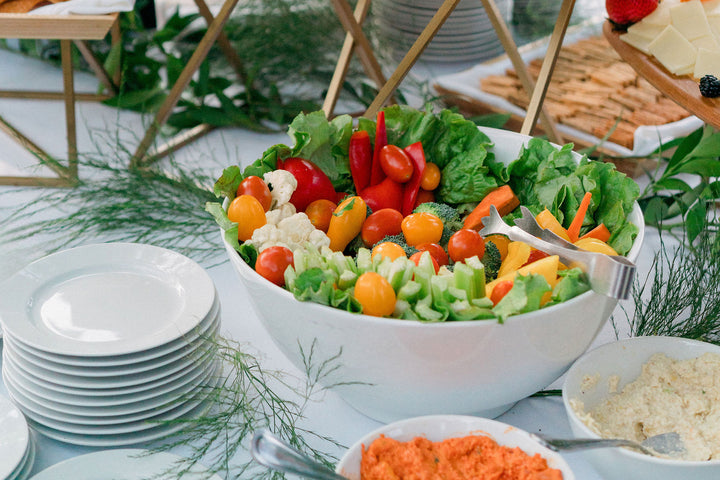 display of vegetables and food in a white bowl on an event table